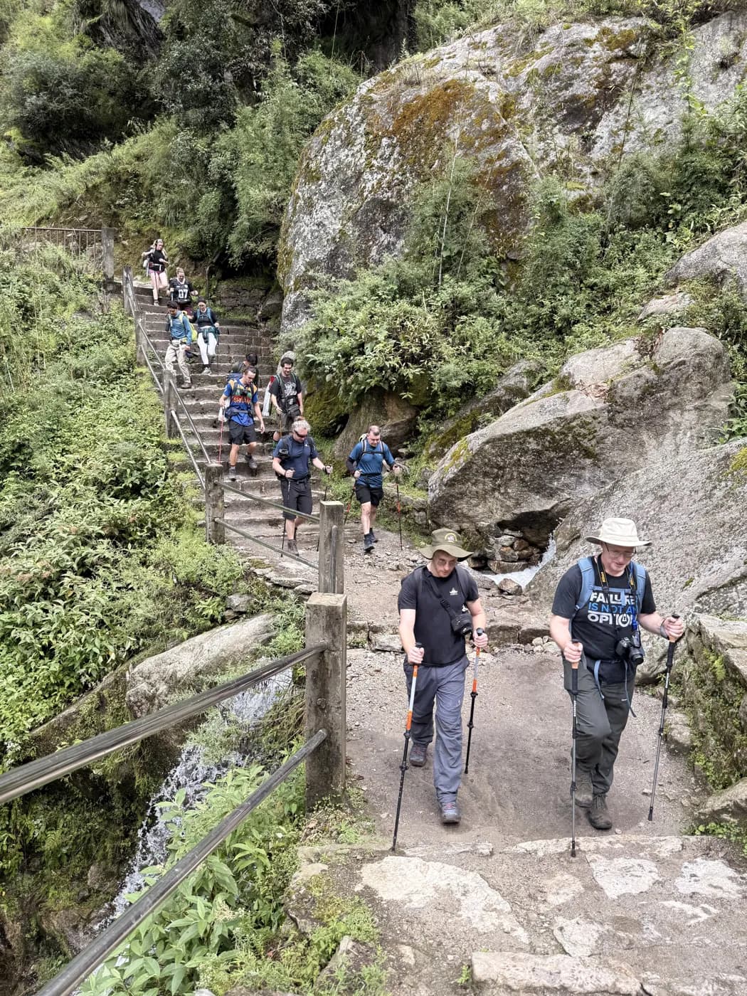 The group climbing stone steps beside a waterfall on the Everest Base Camp trail